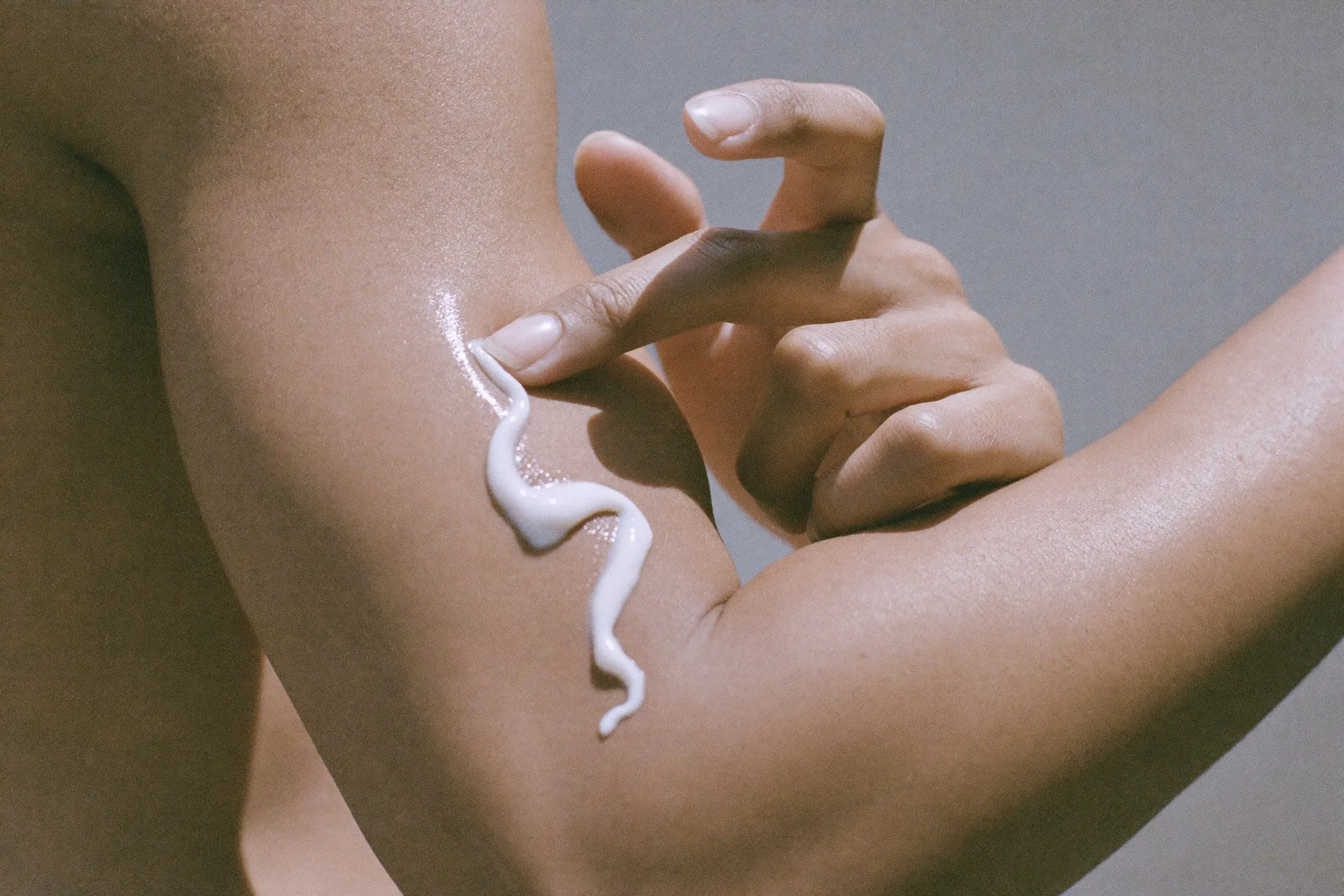 Swatch of sunscreen cream on the back of a man’s hand in daylight