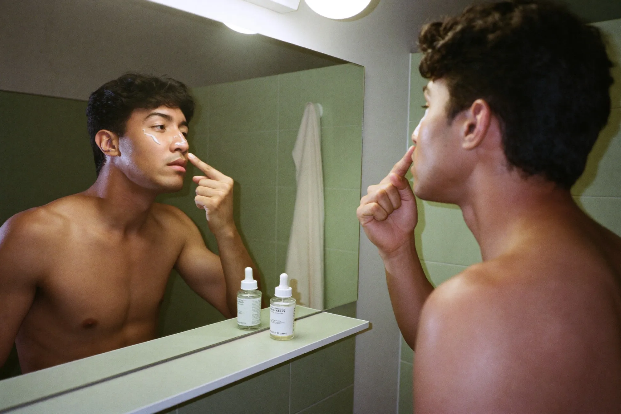 Man applying a thin layer of serum along his nose and cheeks at night