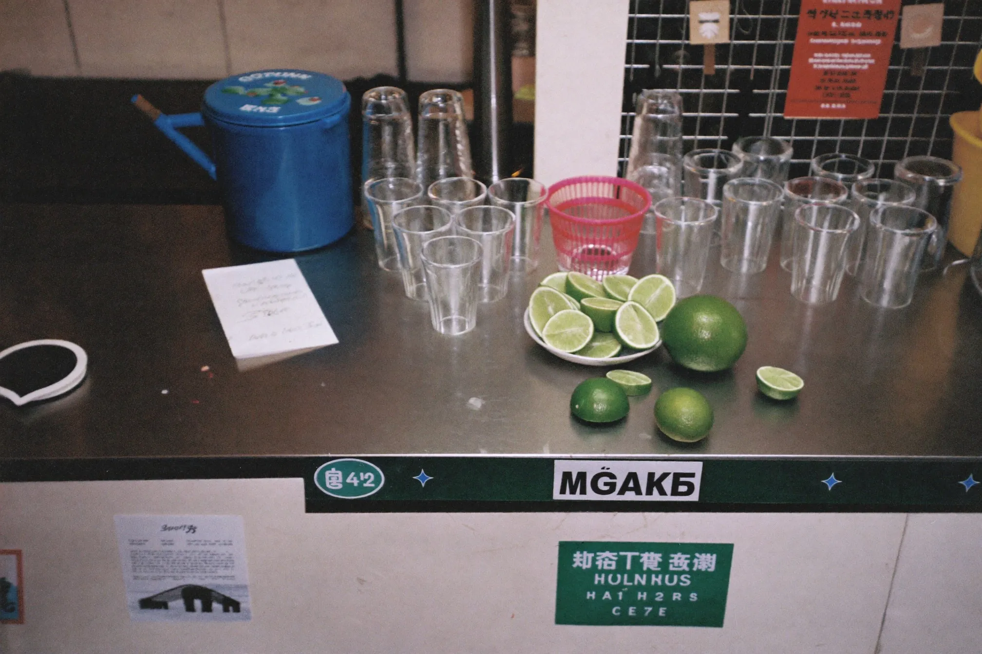 Kitchen counter set up as a drinks station with a bucket of ice, cut limes and mismatched glasses