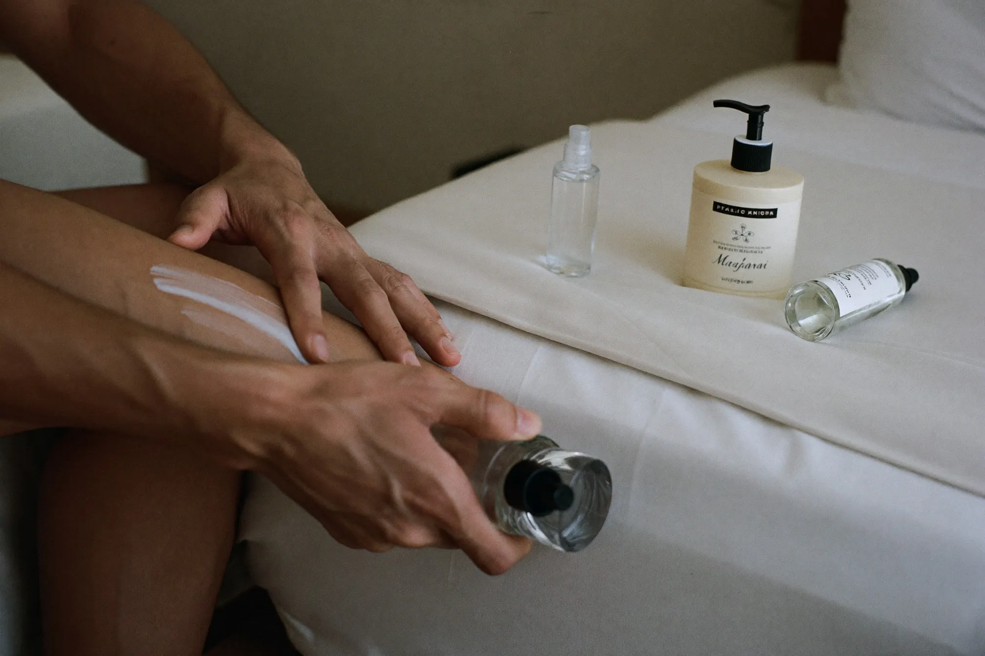 Close view of a man applying unscented moisturiser to the inside of his elbow before spraying fragrance