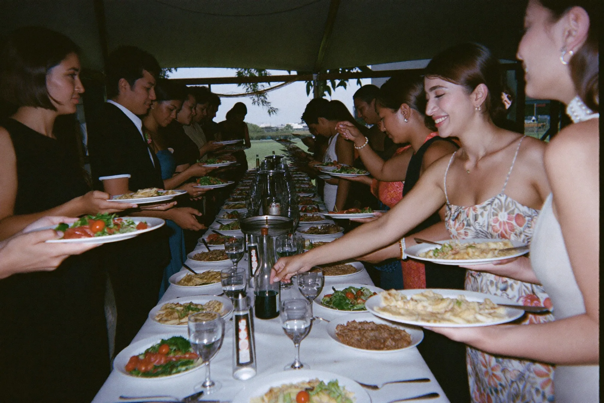 Guests queueing at a kenduri buffet under a canopy
