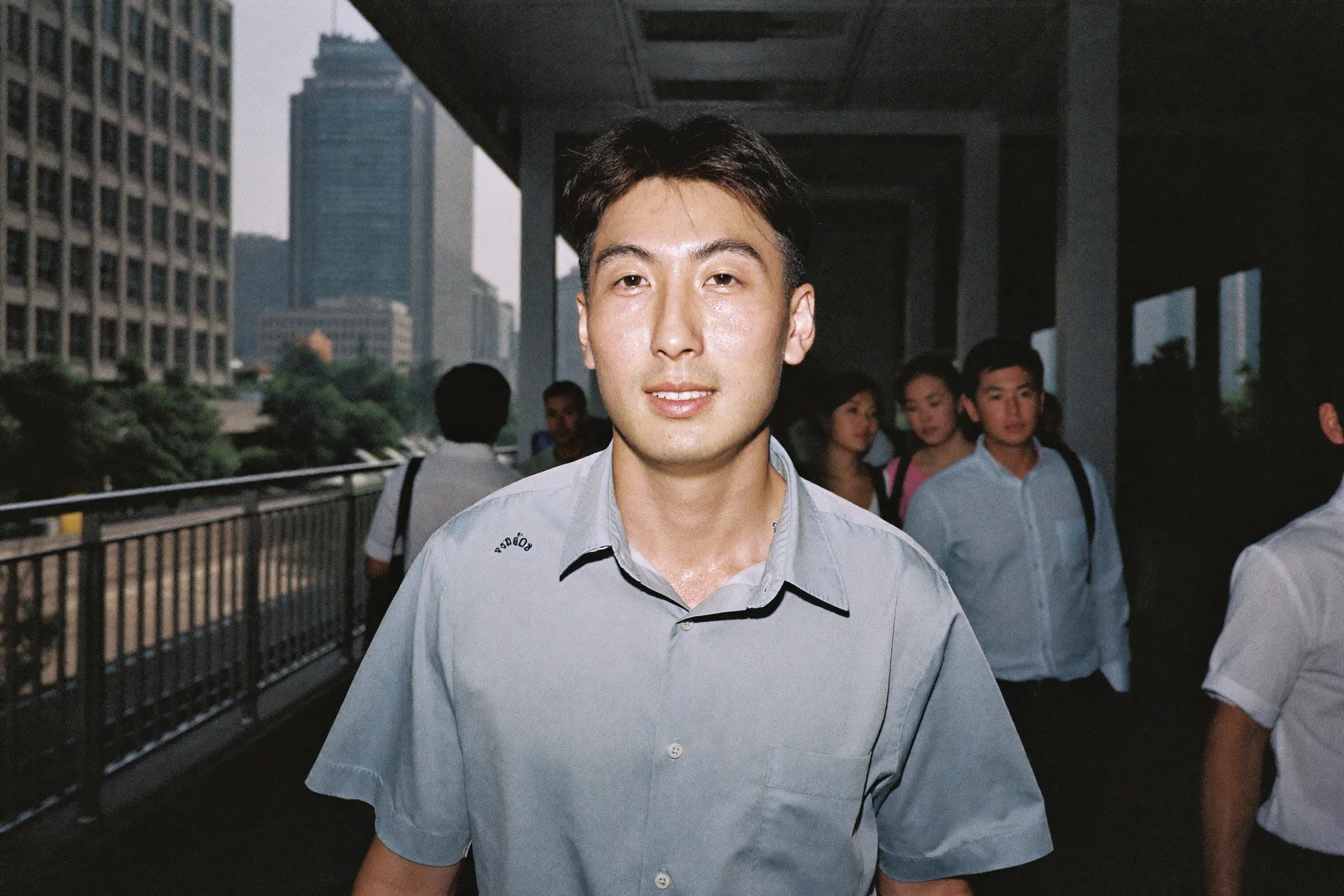 Freshly shaved man in an office shirt walking a covered CBD walkway in the morning heat