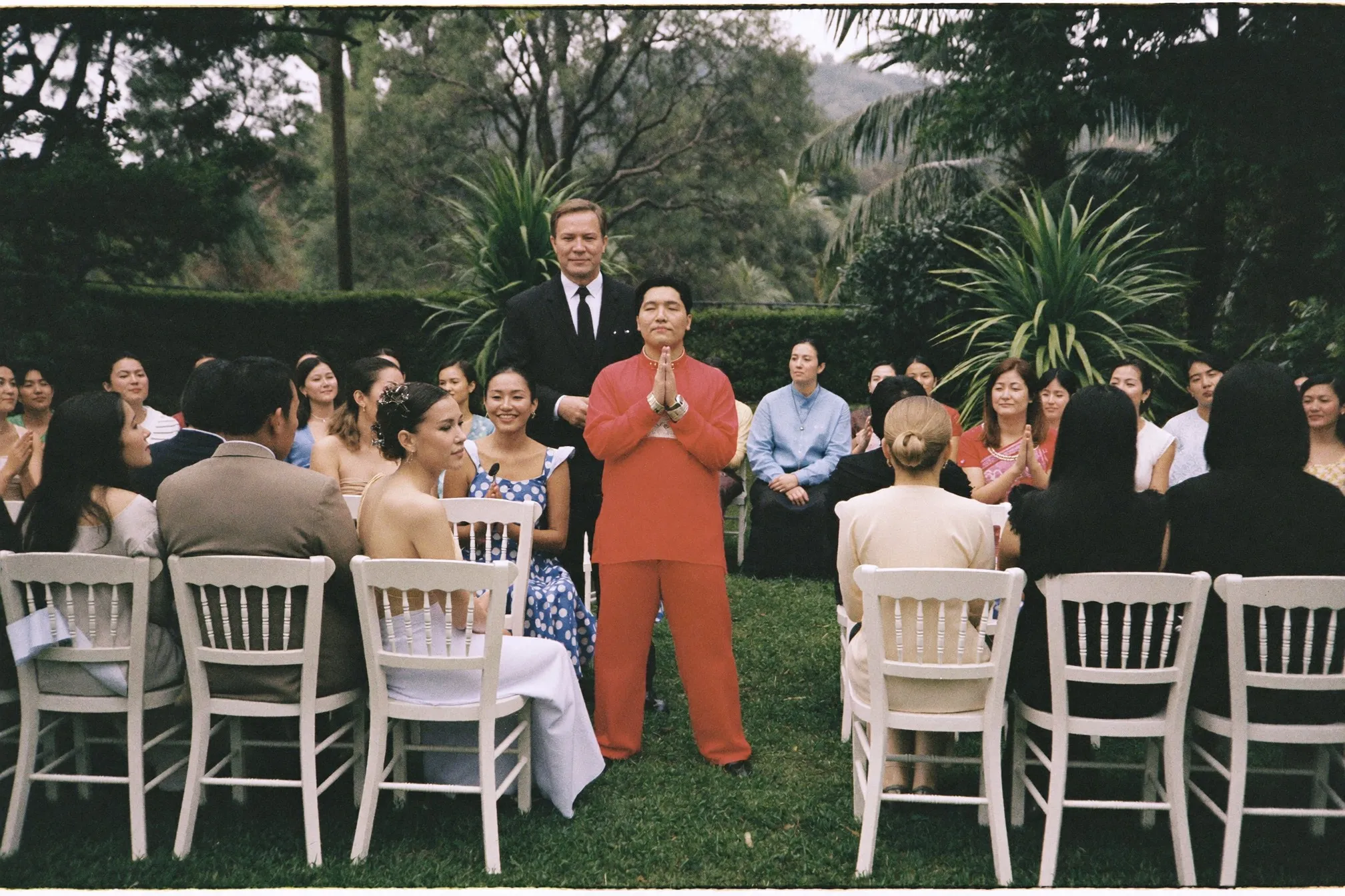 Small outdoor solemnisation ceremony with rows of white chairs at a garden venue