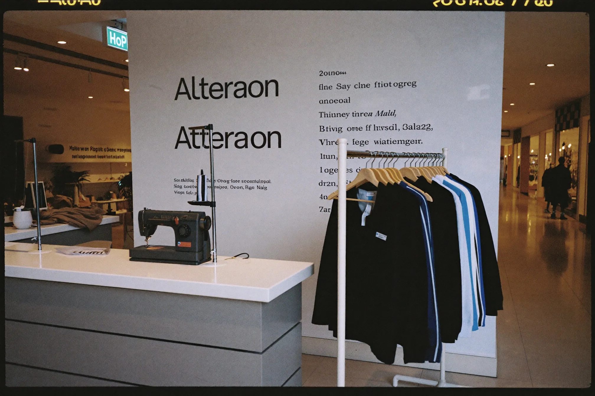 Alteration counter in a shopping mall with a sewing machine and finished garments on a rail