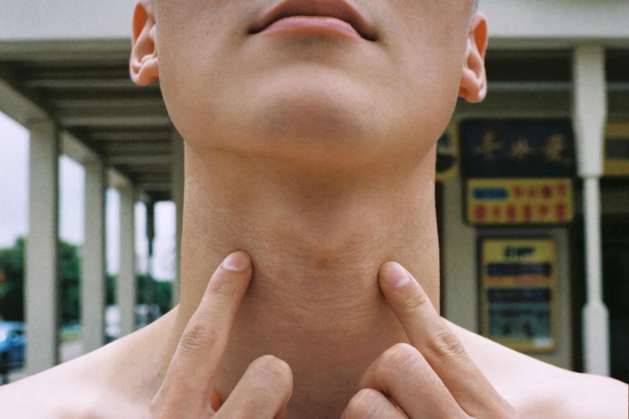 Two sunscreen shade swatches blended along a man's jawline in outdoor daylight